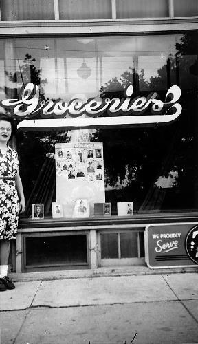 Rita Rojina with her WWII  photo display in Pauly's store front window - 1945